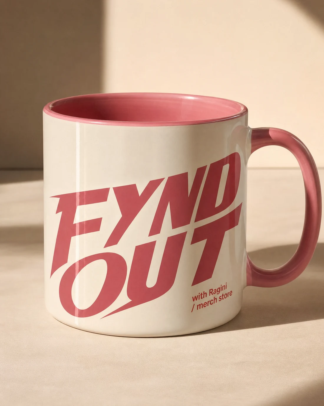 Porcelain mug photographed as a real premium object with the original FYND OUT with Ragini merch-store wordmark integrated into its material.