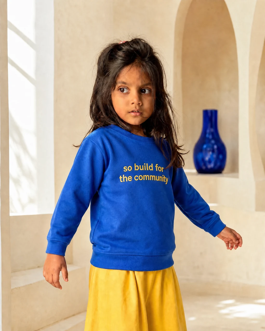 Aarya wearing the Girls So Build For The Community Panel Drop with the exact statement “so build for the community” printed into the garment.